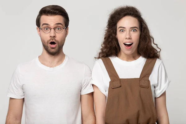 Positively shocked guy and happy girl standing with opened mouths. — Stok fotoğraf
