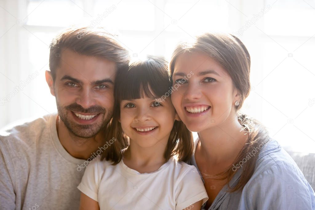 Family portrait of happy parent posing with little daughter