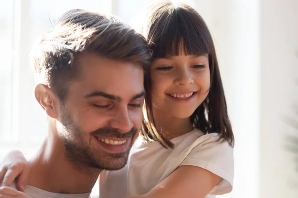 Lächelnde kleine Tochter umarmt jungen Papa zu Hause — Stockfoto