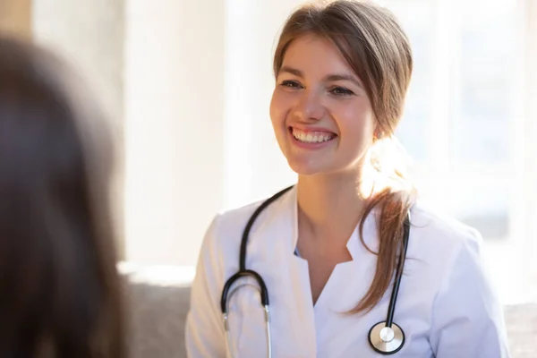Usmívající se doktorka se stetoskopem poslouchat pacienta — Stock fotografie