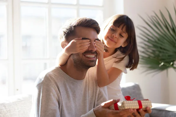 Un petit enfant fait une surprise d'anniversaire à un jeune papa heureux — Photo