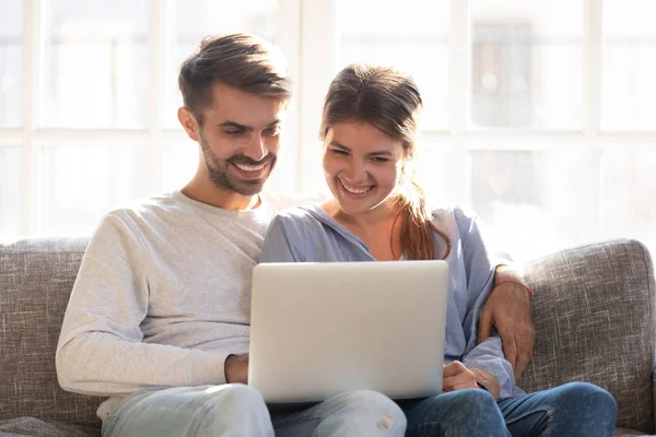 소파에서 노트북으로 비디오를 보는 행복 한 커플 — 스톡 사진