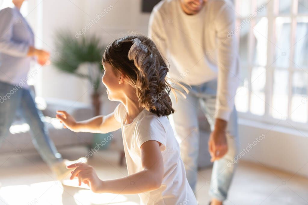 Playful little girl have fun with parents at home
