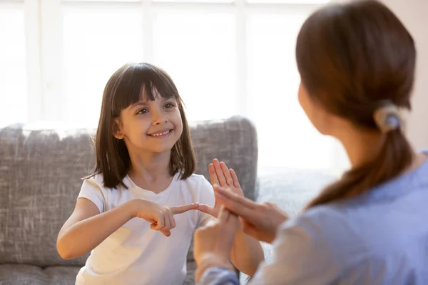 Милая девочка практикует язык жестов с учителем — стоковое фото