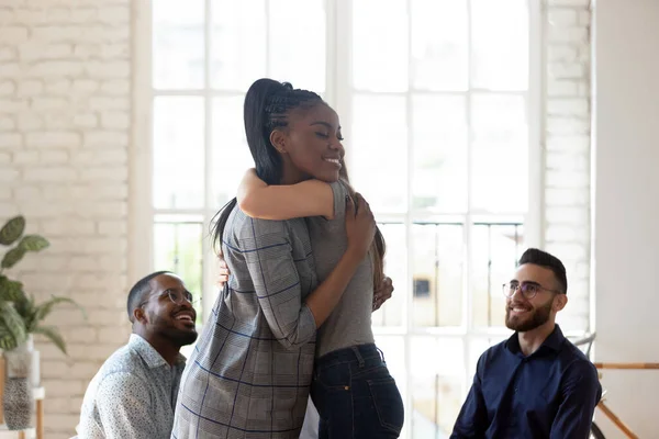 African woman psychologist embracing girl at group therapy session — Stock Photo, Image