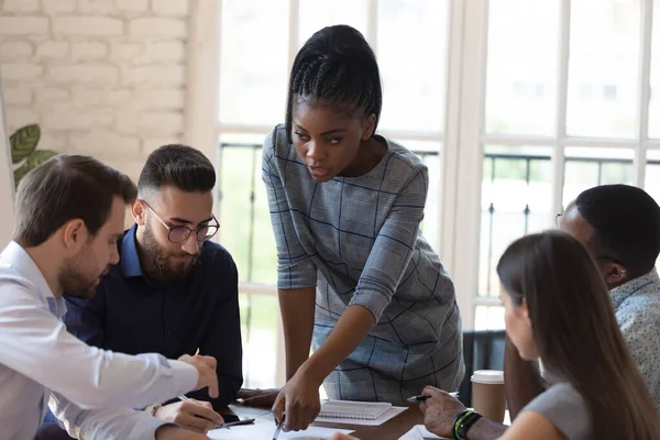 Multinationell företagsgrupp och afrikansk gruppledare som arbetar med projekt — Stockfoto