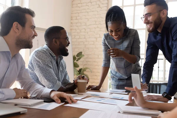 Multi empleados raciales bromeando y riendo durante la sesión informativa en la sala de juntas — Foto de Stock