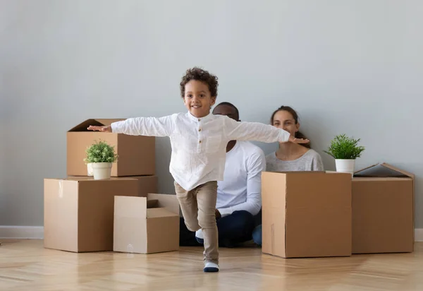 Niño afroamericano feliz con los padres jugando en nuevo apartamento —  Fotos de Stock