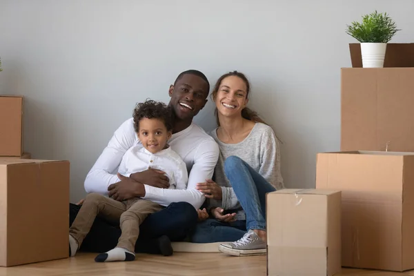 Portrait happy African American family with boxes in new apartment — Stok fotoğraf