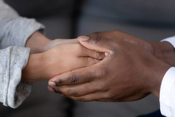 Acercamiento afroamericano hombre y mujer enamorados tomados de la mano — Foto de Stock