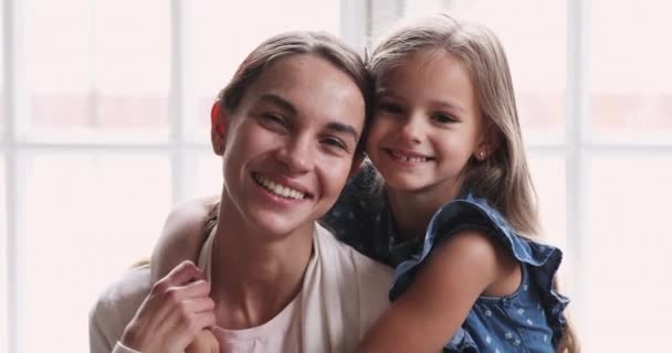 Pretty uśmiechnięte dziecko córka przytulić mama patrzeć w aparat — Wideo stockowe