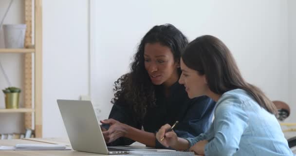 Empresárias mistas motivadas que trabalham em conjunto em projectos no local de trabalho . — Vídeo de Stock