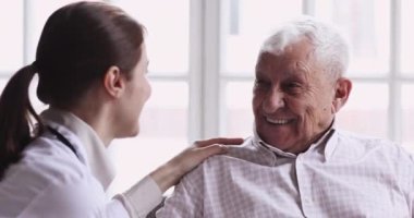 Sağlıklı gülümseyen son sınıf öğrencisi, ilgili genç bayan doktorla konuşuyor.