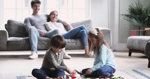 Kinderen en ouders brengen weekend familietijd door in de woonkamer — Stockvideo