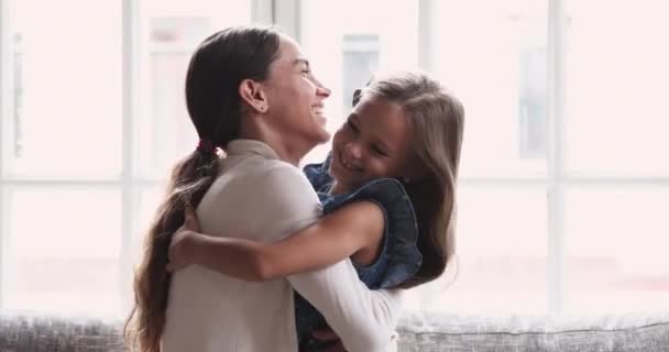 Speelse moeder en schattig kind dochter spelen knuffelen op de bank — Stockvideo