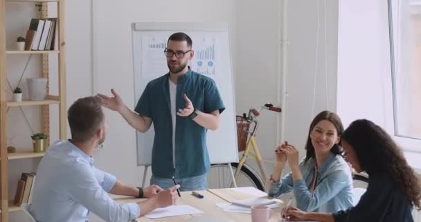 Jonge creatieve mannelijke manager leider bespreekt projectideeën met teamgenoten. — Stockvideo