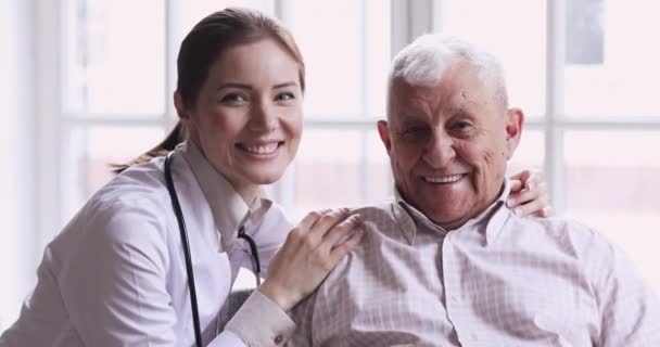 Счастливый пожилой пациент и женщина-врач смотрят в камеру — стоковое видео