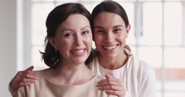 Joyful mature mommy and young daughter embracing laughing, portrait — Stockvideo