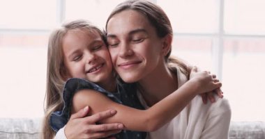 Sevecen, genç bir anne, sevimli bir çocuğa sarılıyor ve hassas anın tadını çıkarıyor.