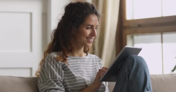 Lachende aantrekkelijke vrouw met behulp van dating applicatie op digitale tablet. — Stockvideo