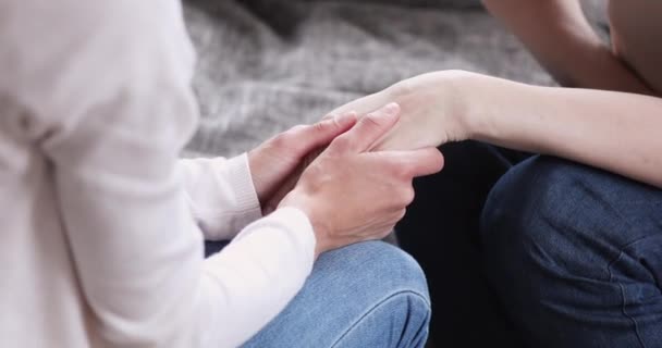 Las manos femeninas jóvenes toman la mano de la anciana vista de cerca — Vídeo de stock