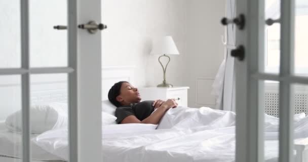 Jovem mulher africana feliz alongamento acordar na cama acolhedora — Vídeo de Stock