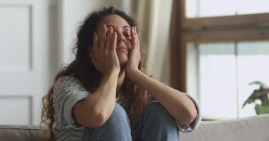 Dizlerini kucaklayan, kişisel sorunları düşünen hayal kırıklığına uğramış genç bir kadın..