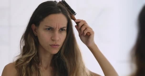 Stressed millennial mulher de raça mista escovar o cabelo . — Vídeo de Stock