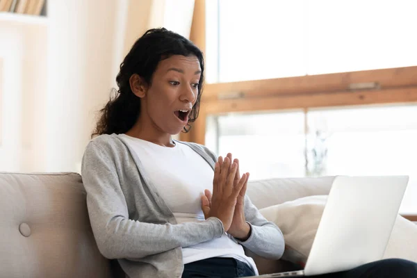 Surprised biracial woman stunned by unbelievable message on laptop — 图库照片