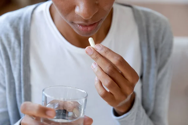 Mujer afroamericana se siente enferma tomando píldora en casa — Foto de Stock