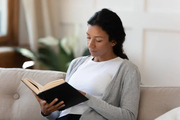 Mujer afroamericana relajarse en el sofá libro de lectura — Foto de Stock