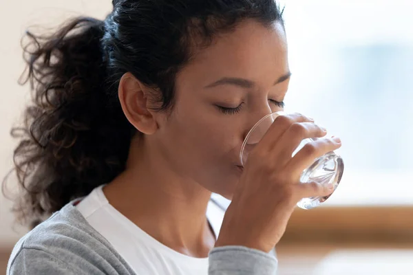 Mujer afroamericana sedienta bebiendo agua mineral — Foto de Stock
