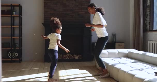 Маленька африканська дівчинка танцює плескаючи руками з молодою мамою . — стокове відео
