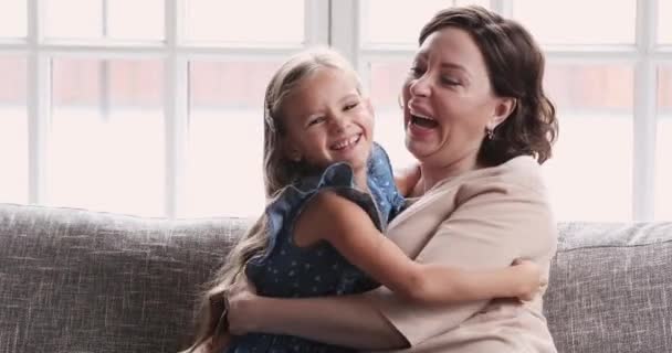 Gelukkige liefdevolle oma en kind kleindochter kietelen knuffelen op de bank — Stockvideo