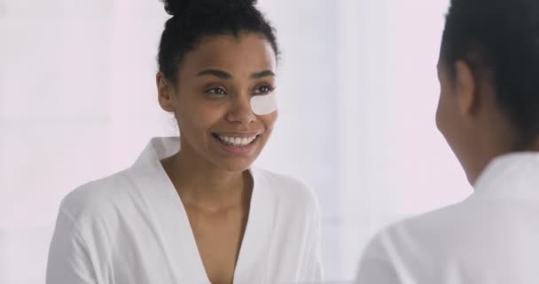 Attractive african american woman using eyes patches. — Stock Video