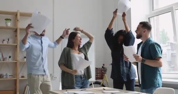 Emocionados jóvenes multirraciales divirtiéndose juntos en la oficina . — Vídeos de Stock