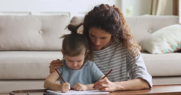Affectionate jonge vrouw babysitter knuffelen klein schattig kind, tekenen samen. — Stockvideo