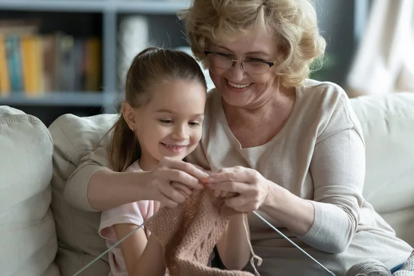 Happy senior grandmother and little granddaughter knit together — Stock Fotó