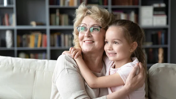 Happy mature grandmother and little granddaughter visualizing together — Stockfoto