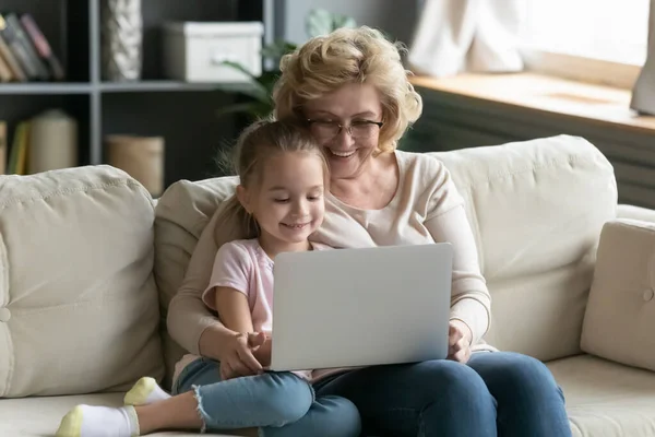 Nenek yang gembira menggunakan laptop dengan cucu kecilnya — Stok Foto