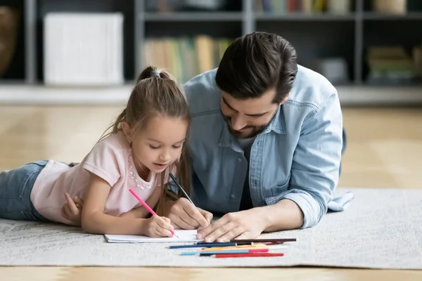 Papá joven se divierte dibujando con su hija pequeña — Foto de Stock