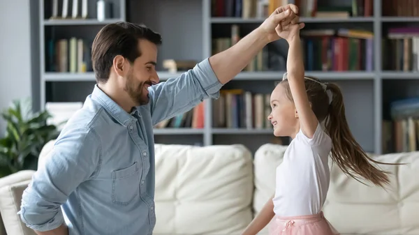 Joven padre bailando con su pequeña hija emocionada en casa —  Fotos de Stock