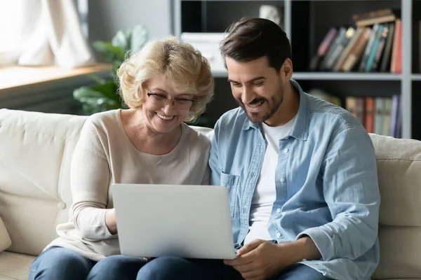 Feliz anciano mamá y adulto hijo usando el ordenador portátil en casa — Foto de Stock