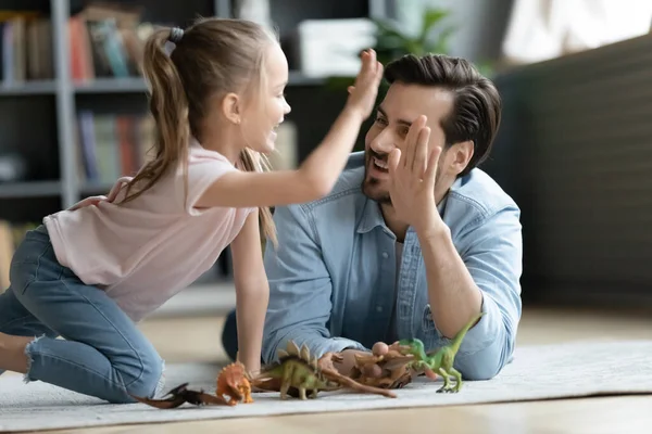 Alegre papá joven y su hija pequeña juegan juntos en casa — Foto de Stock