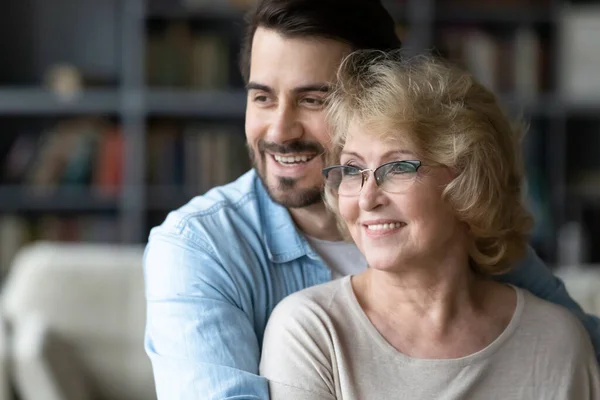 Hopeful senior mom and adult son visualize together — Stockfoto