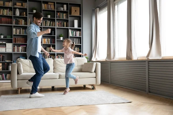 Alegre papá joven y la pequeña hija bailando en casa —  Fotos de Stock