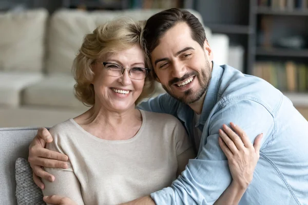 Dankbar jung mann umarmen senior mama relaxen zu hause — Stockfoto