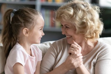 Neşeli yetişkin büyükanneniz küçük torununuzla konuşurken iyi eğlenceler.