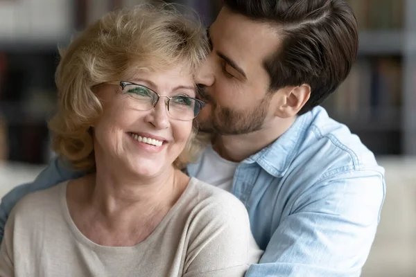Liebender erwachsener Sohn umarmt glückliche Seniorin und zeigt Dankbarkeit — Stockfoto