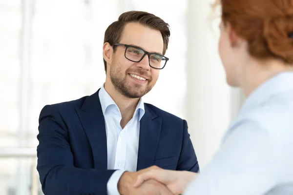 Close-up glimlachende man handdrukken met baas bij vergadering. — Stockfoto